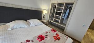 a bedroom with a bed with red flowers on it at Berg'hotel in Socx