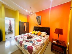 a bedroom with orange walls and a bed with a bedspread at Alha Villa in Baie Lazare Mahé +63 photos