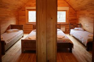 a room with two beds in a wooden cabin at Wild Duck in Jaunjelgava