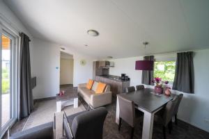 a living room with a table and a couch at EuroParcs Markermeer in Bovenkarspel