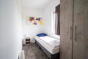 a small bedroom with a bed and a cabinet at EuroParcs Markermeer in Bovenkarspel