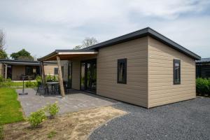 a small shed with a table and a patio at EuroParcs Markermeer in Bovenkarspel +52 photos