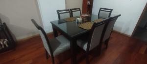 a dining room table with four chairs and a black table at LUANAIRAM Home in Cusco