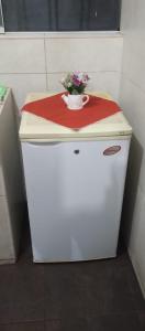 a small white refrigerator with a vase of flowers on top at LUANAIRAM Home in Cusco