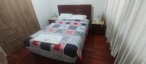 a bedroom with a bed with two white towels on it at LUANAIRAM Home in Cusco