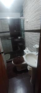 a bathroom with a shower and a toilet and a sink at LUANAIRAM Home in Cusco