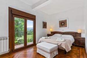 a bedroom with a bed and a large window at La casona de La Garaba in Grado