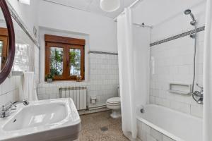 a white bathroom with a sink and a toilet at La casona de La Garaba in Grado +26 photos