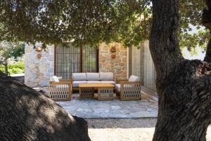 a patio with a couch and chairs under a tree at Odette Pansiyon Bodrum in Bodrum City +90 photos