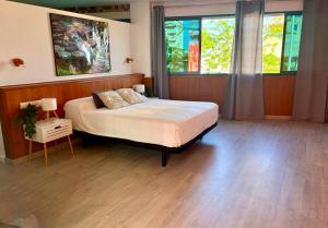 a bedroom with a large bed and two windows at Gandia Confort Treviso in Gandía +26 photos