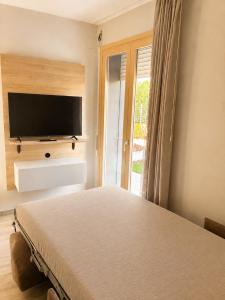 a bedroom with a bed and a flat screen tv at Approdo del Re in Grottammare