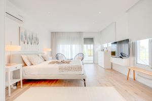 a white bedroom with a bed and a kitchen at Seaside Hideaway Villa in Perivolia