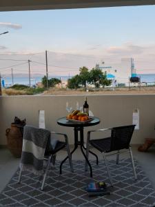 a table with a bottle of wine and fruit on it at Prikas Apartments A in Kefalos