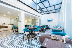 ein Restaurant mit blauen Stühlen und Tischen in einem Raum in der Unterkunft Hotel Limon & Banquet Sector 29, Gurgaon in Gurgaon