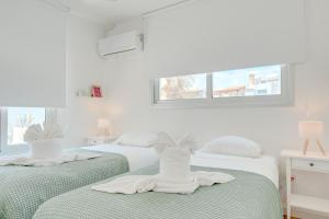two beds in a bedroom with white walls and a window at Seaside Hideaway Villa in Perivolia +57 photos