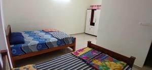 a room with two beds and a bench in it at Roamwander APARTMENT in Vagamon
