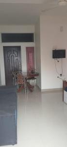 a room with a table and chairs and a door at Roamwander APARTMENT in Vagamon