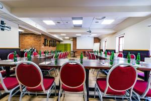 a conference room with tables and red chairs at Hotel Purkmistr Beer & Spa Resort in Pilsen +212 photos