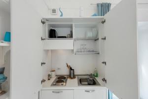 a kitchen with white cabinets and a sink at Casa Vacanza Sunshine in Meta +68 photos