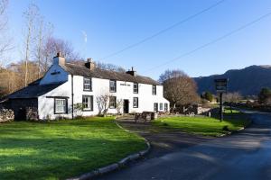 a white house on the side of a road at Strands Hotel/Screes Inn & Micro Brewery in Nether Wasdale