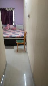 a small room with a chair and a bed at priyadarshi in Digha +8 photos