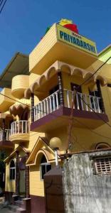 a yellow building with a balcony on top of it at priyadarshi in Digha