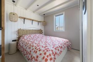 a bedroom with a bed with a red and white comforter at Martinette in Saint-Pair-sur-Mer +17 photos