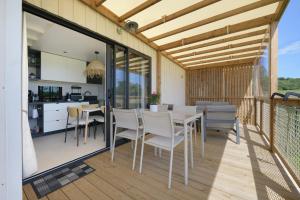 a patio with a table and chairs on a deck at Martinette in Saint-Pair-sur-Mer