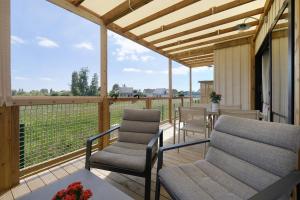 a screened porch with two chairs and a table at Martinette in Saint-Pair-sur-Mer