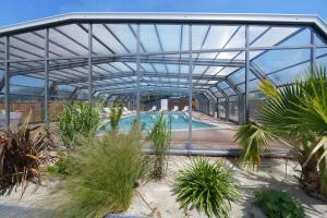 a swimming pool in a greenhouse with plants at Martinette in Saint-Pair-sur-Mer