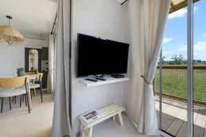 a living room with a flat screen tv on a wall at Martinette in Saint-Pair-sur-Mer