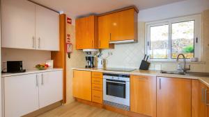 a kitchen with wooden cabinets and a sink at Clube Alvor Ria - Prime Residence in Alvor