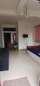 a room with a bed and a living room with a table at Roamwander APARTMENT in Vagamon