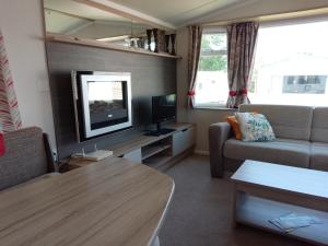 a living room with a couch and a television at Weymouth Bay Holiday Static Caravan in Preston