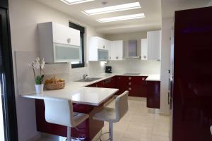 a kitchen with white cabinets and a table and chairs at Villa Thea, By IdealStay Experience in Kaloi Limenes +28 photos