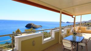 a balcony with a table and a view of the ocean at Villa Thea, By IdealStay Experience in Kaloi Limenes