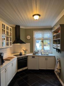 a kitchen with white cabinets and a sink and a window at Leilighet i villa, 3 soverom med parkering-nær sentrum - Open for ONS 2026 in Stavanger