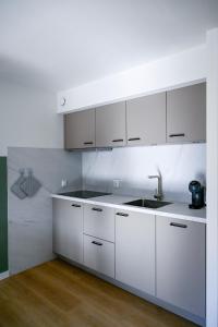 a kitchen with white cabinets and a sink at Waddenhuyske in Hollum