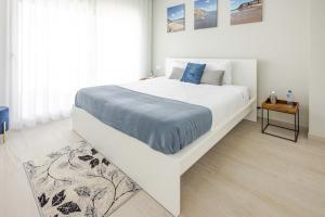 a bedroom with a large white bed with a blue blanket at Villa Atlantica One Sea View - Pool - Sunset in Lourinhã