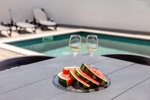 a plate of watermelon and two glasses of wine at Villa Atlantica One Sea View - Pool - Sunset in Lourinhã