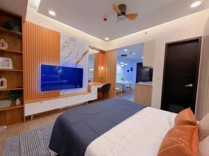 a bedroom with a large bed and a flat screen tv at Gabbys Place in Bacolod