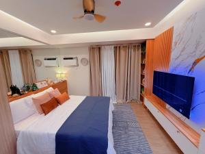 a bedroom with a large bed and a flat screen tv at Gabbys Place in Bacolod