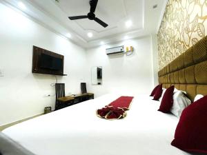 a bedroom with a large white bed and a flat screen tv at Hotel Embassy In - 200 Mtrs - Near Golden Temple in Amritsar