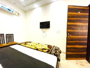 a bedroom with a bed and a wooden door at Hotel Embassy In - 200 Mtrs - Near Golden Temple in Amritsar