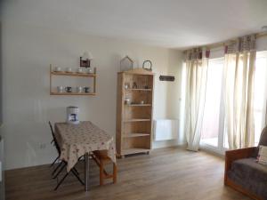 a living room with a table and a chair at Appartements Les Balcons du Soleil in Font-Romeu