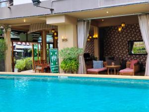 a pool in front of a hotel with a restaurant at Wualai Boutique by Lanna Oriental in Chiang Mai
