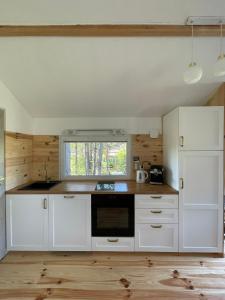 a kitchen with white cabinets and a window at Rest-Inn Timber-Lake in Kłodno