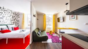 a small room with a bed and a desk in it at Pop Hôtel in Dijon