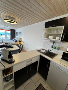 a kitchen with a sink and a living room at Allgäuauszeit mit Bergblick - Sauna - Balkon in Scheidegg