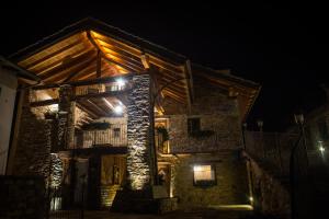 una casa de piedra por la noche con luces encendidas en Souvenir De Tsaneli, en Roisan